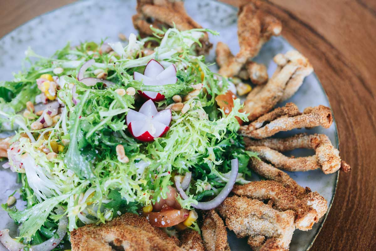 Knusprige Enoki-Pilze auf Frisée-Gemüsesalat