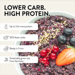 Close-up of a dark berry porridge with fresh fruit and hemp seeds. Benefits listed: Up to 3.5x more protein, 50% fewer carbs, ready in 3 min, sustainably grown soy from Germany.