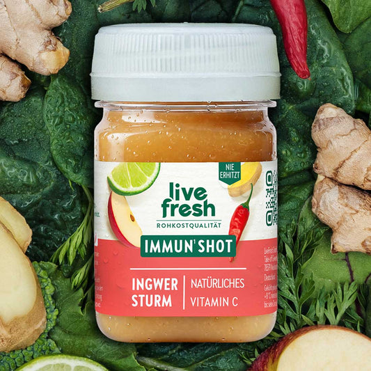 LiveFresh Immun Shot Ingwer Sturm zwischen Blattgemüse Ingwer Chili Apfel und Limette. Auf dem Etikett steht "live fresh Rohkostqualität Immun Shot Ingwer Sturm Natürliches Vitamin C".
