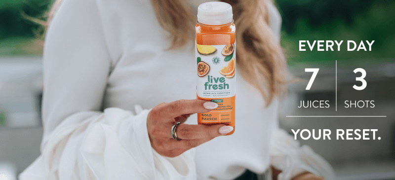 Woman in a white blouse is holding a bottle of 