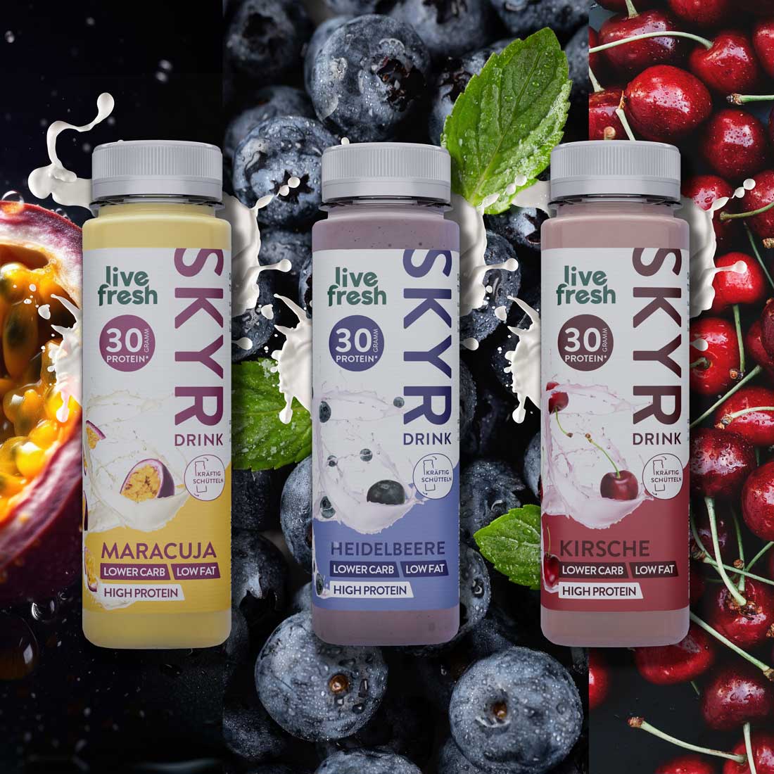 Drei Flaschen Skyr-Drink von 'live fresh' in den Geschmacksrichtungen Maracuja, Heidelbeere und Kirsche vor den entsprechenden Früchten. Jede Flasche zeigt '30g Protein', 'lower carb, low fat, high protein' und 'kräftig schütteln', mit weißen Spritzern, die die cremige Textur des Drinks betonen.